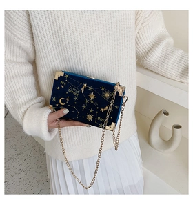 Détail du sac boîte en velours bleu marine avec broderie céleste dorée et chaîne