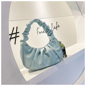 Detail of mint green pleated cloud bag showing soft texture and folded handle design