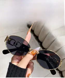 Close-up of grey oval lenses with gold hollowed metal frames and temple detail