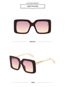 Detail view of square large frame sunglasses with pink-yellow gradient lenses and wave temples