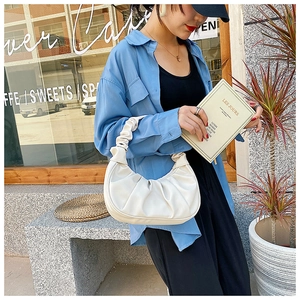Detailed close-up showing the pleated texture and handle of the white cloud shoulder bag