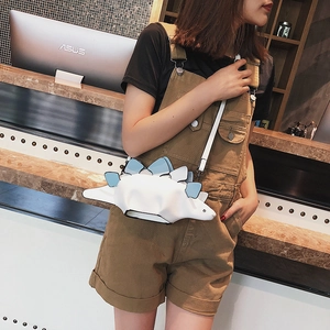 Quirky white dinosaur crossbody bag with blue scales for women in a casual indoor setting