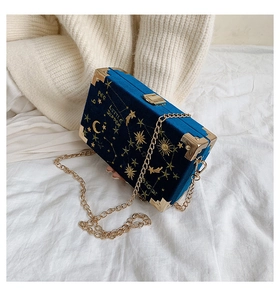 Broderie détaillée d'étoiles et de lune sur un sac boîte en velours bleu avec dorures