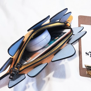 Cute yellow dinosaur crossbody bag with blue fins showing internal storage for smartphone