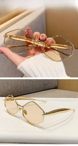 Detail view of geometric metal sunglasses with light gold frames and brown lenses