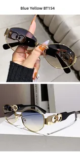 Detail of blue-yellow gradient sunglasses with hollow gold metal temples on a white stone base