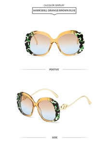 Detail of tortoise shell sunglasses with blue gradient lenses and gold heart hinges