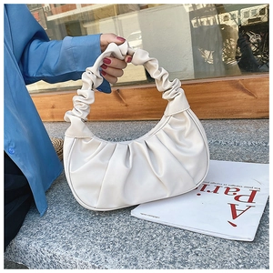 Close-up of white pleated cloud bag with elegant organza textures and soft leather handle