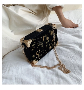 Détails de broderie d'étoiles dorées sur un sac boîte en velours noir élégant