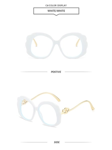 Detail of white oval sunglasses with gold double heart hollow temples and wave frame edge