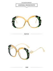 Detail of oval sunglasses with hawksbill orange texture and gold double-heart hinge