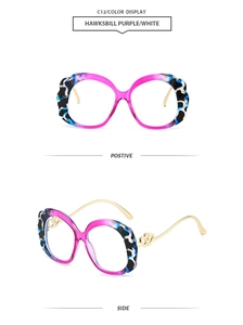 Detail of purple and white tortoiseshell frame with golden heart hinge ornaments