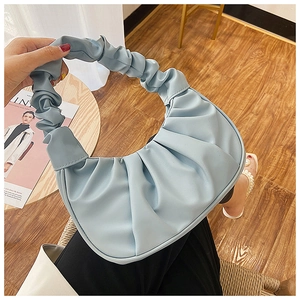 Detailed view of the ruched light blue crescent dumpling bag with pleated handle texture