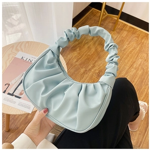 Close-up of light blue pleated dumpling bag featuring soft ruched texture and cloud handle