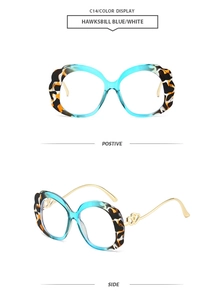 Detail view of oval sunglasses with hawksbill blue and white frames and heart temple accents