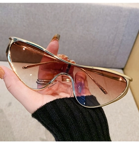 Détail de lunettes de soleil masque dorées surdimensionnées avec verres dégradés marron Y2K