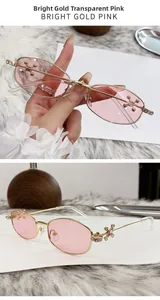 Detailed view of gold metal sunglasses with pink lenses and rhinestone star hinges