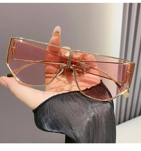 Detail of trendy oversized sunglasses with gold metal frame and purple gradient lenses