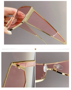 Detail of pink lenses and golden metal temples on modern oversized sunglasses