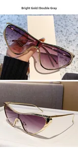Détails de lunettes de soleil œil de chat dorées avec des verres dégradés gris chic