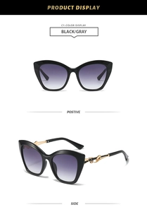 Détail de lunettes de soleil œil de chat noires avec décor doré et verres dégradés