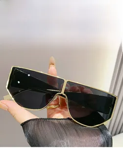 Detail of oversized gold metal sunglasses with grey lenses and futuristic fashion style