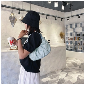 Detail of light blue ruched cloud bag showing soft pleated texture and shoulder strap style