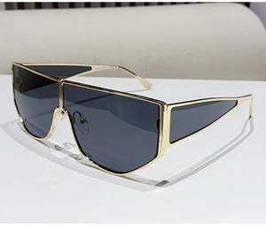 Detail view of gold shield sunglasses with geometric hollow temples and grey lenses