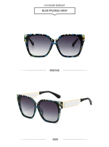 Detail view of square blue floral sunglasses with gold metal arms and gradient gray lenses