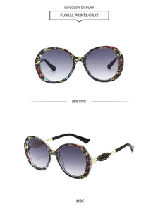 Detail of oversized floral print sunglasses with gray gradient lenses and golden metal accents