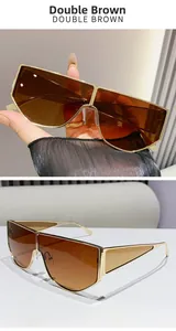 Detail of oversized metal sunglasses with double brown gradient lenses and gold bridge