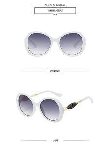 Detail view of retro white oversized sunglasses with gradient lenses and gold leaf decor