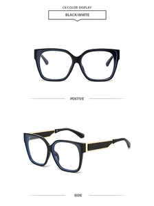 Detail of square oversized sunglasses with black frame, blue inner rim and gold metal trim