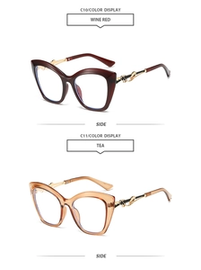Détail de lunettes de soleil œil-de-chat bordeaux et thé avec décor musical doré en métal