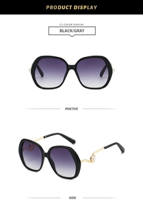 Detailed view of women's black round sunglasses with gold wave temples and pearl accents