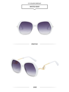 Detail of white wide-frame sunglasses with purple gradient lenses and pearl-inlaid temples