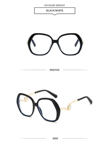 Detail of round sunglasses with black frame, wavy gold metal temples and pearl accent
