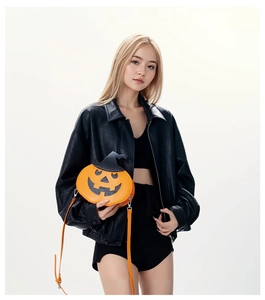Detail of creative pumpkin shoulder bag featuring a black witch hat and orange leather texture