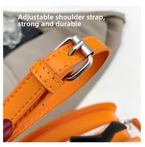Close-up of adjustable orange leather shoulder strap with durable silver metal buckle