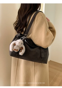 Détail du cabas en cuir mat marron foncé avec pendentif lapin en peluche et boucle