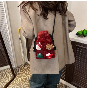 Detail of red plush Christmas crossbody bag with festive Santa and reindeer patches