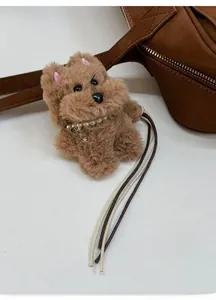 Colgante de perro de peluche marrón con collar de perlas y placa de hueso en bolso