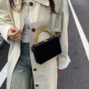 Détail du sac boîte en velours noir avec poignée en bambou dorée et bandoulière chaîne