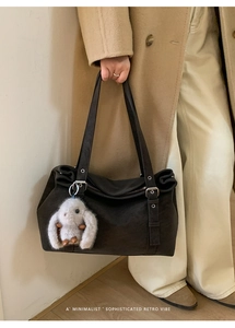 Detail of retro tote bag with plush bunny charm and minimalist aesthetic style