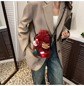 Red festive velvet crossbody bag with Christmas motifs shown in a lifestyle model shot