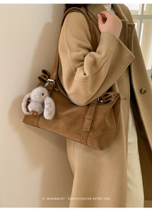 Détail d'un grand cabas en daim marron avec boucle métallique et breloque lapin