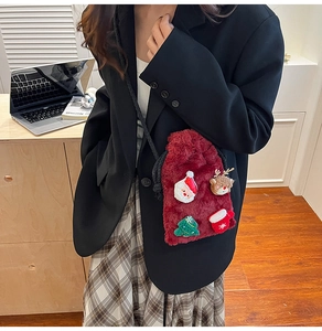 Detail of red plush crossbody bag with Christmas motifs and black woven shoulder strap