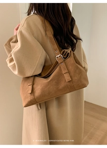 Gros plan d'un sac cabas en daim marron avec boucle métallique sur bandoulière pour femme