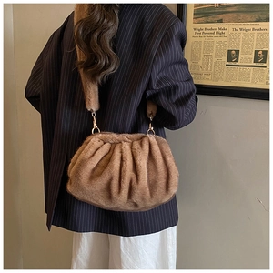 Detail of a brown faux fur cloud bag showing plush texture and gold metal hooks on the strap