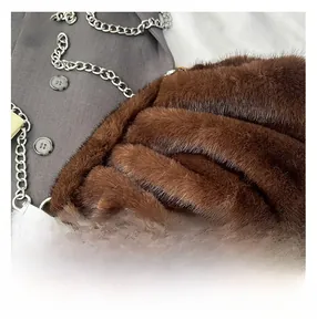Détail du sac à main en fausse fourrure marron foncé avec grosse chaîne argentée